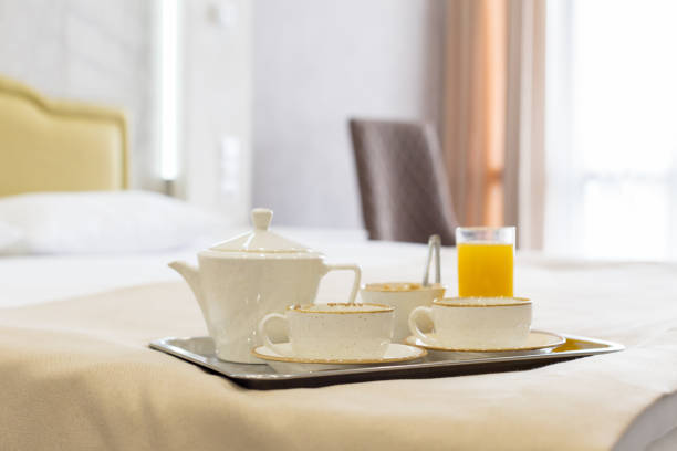 istock Two white mugs on a tray white bed, breakfast concept 1151198503
