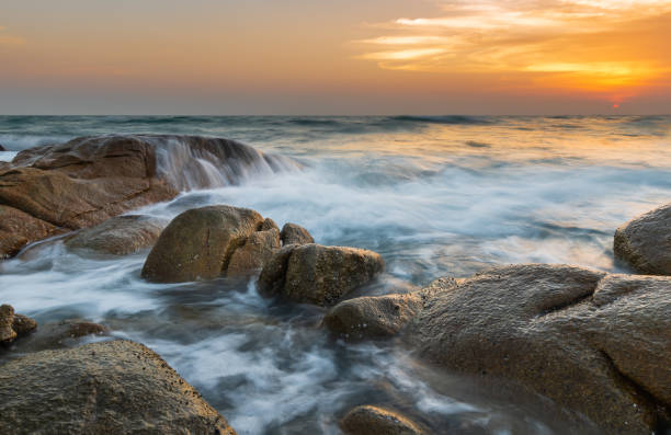 istock The rock and smooth sea wave in the sunset time. 1151200810