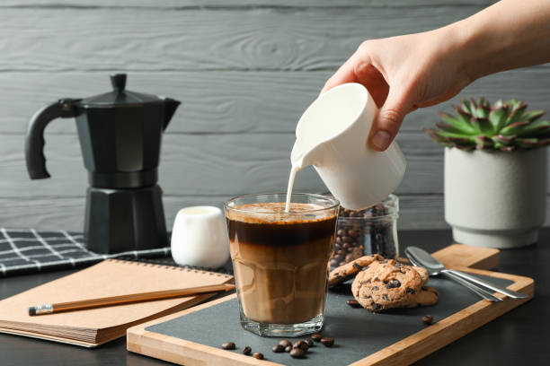 istock Coffee time accessories with female hand on black table against grey background, space for text. Break time 1151200825