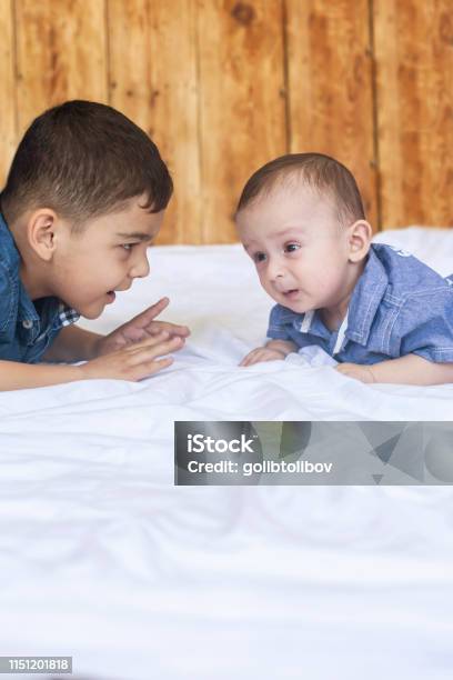 Happy Brothers Two Cute Little Brothers Lying On Bed Together Stock Photo - Download Image Now