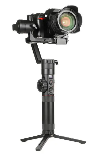 Gimbal three-axis motorized stabilizer with mounted DSLR camera isolated on white background