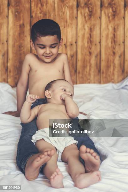 Happy Brothers Two Cute Little Brothers Lying On Bed Together Stock Photo - Download Image Now