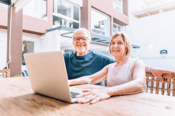 istock Happy senior couple using laptop at home 1151202240