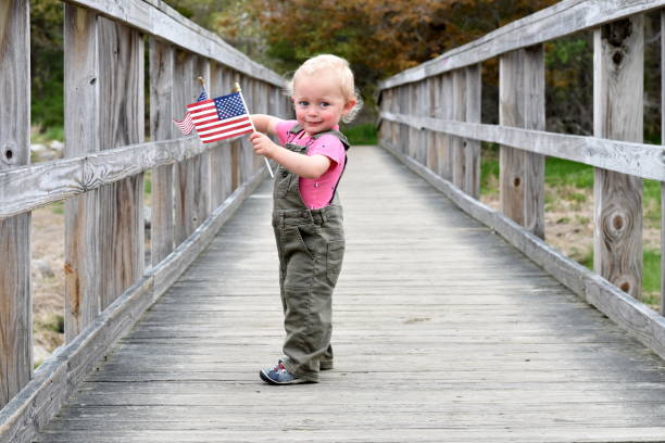 istock Young Boy Carrying American Flag Over Bridge 1151202722