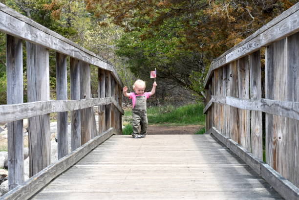 istock Young Boy Carrying American Flag Over Bridge 1151203421