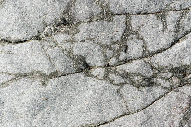 istock Close-up macro view of cracked stone surface grey color. Detailed nature background or pattern texture 1151207502