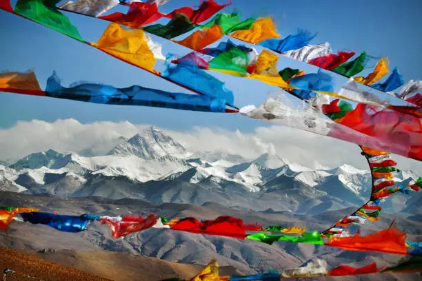Mount Everest in Himalayas of Tibet viewed at distance through Buddhist prayer flags strewn across a high Himalayan Mountain pass
Everest, known in Nepali as Sagarmatha and in Tibetan as Chomolungma, is Earth's highest mountain above sea level, located in the Mahalangur Himal sub-range of the Himalayas. The international border between Nepal and China runs across its summit point