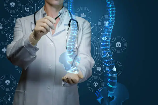 Worker of medicine treats the human spine on blue background.