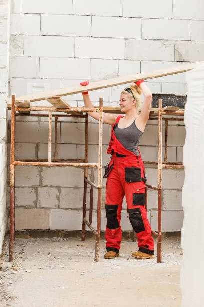 istock Woman carrying plank boards on construction site 1151208584