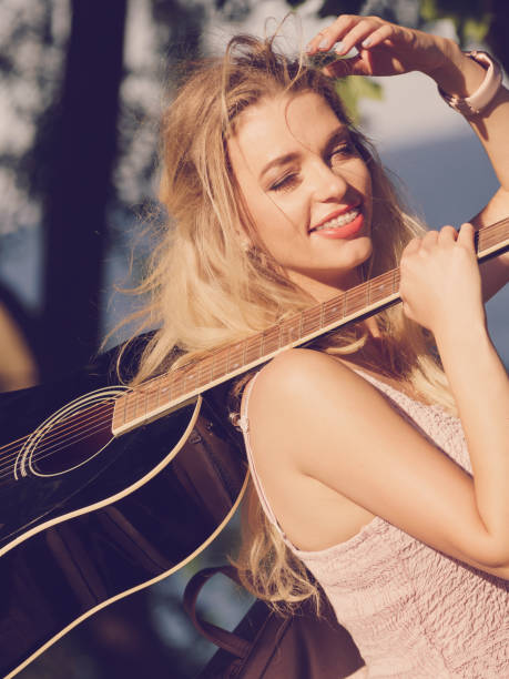 istock Woman playing acoustic guitar in park 1151208883