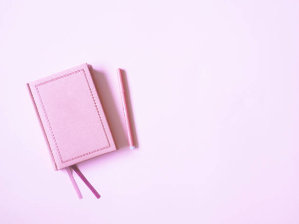 istock Pink diary with a pen on a pink background. 1151210443