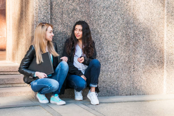 istock two female students talking by the wall 1151210516