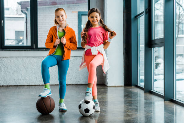 istock Confident kids posing with balls in gym 1151211413