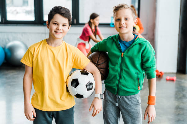 istock Smiling boys holding balls and looking at camera 1151211473