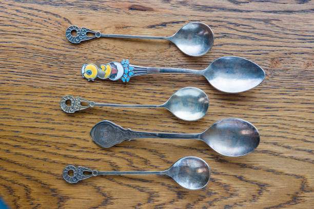 istock Five antique, decorative spoons on an oak table 1151211806
