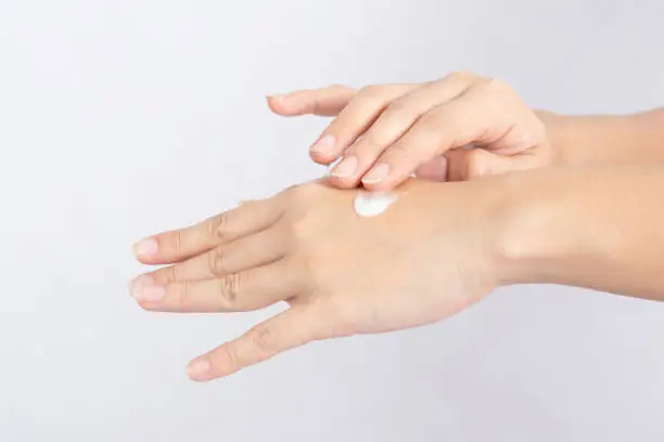 Close up hands of woman with cream lotion apply on her hands feeling so happiness and cheerful for 
Moisture her healthy skin,Skincare Concept