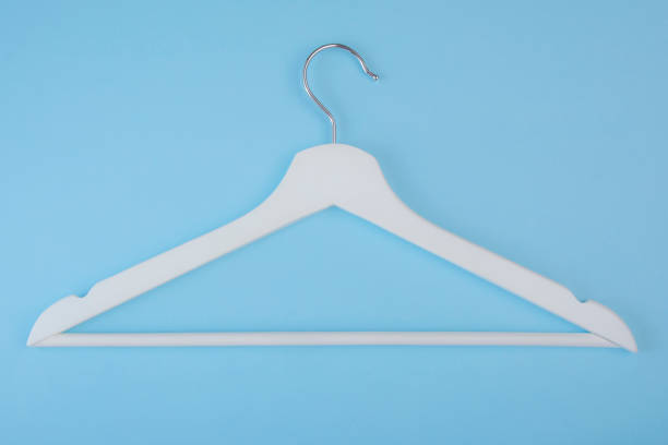 istock White wooden hanger isolated on blue background. Copy space for text. 1151216567
