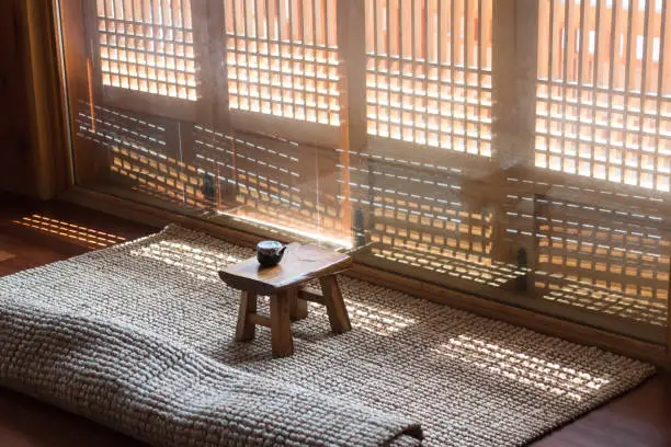 Korean traditional wooden tea table with sunlight through tradional door gratings