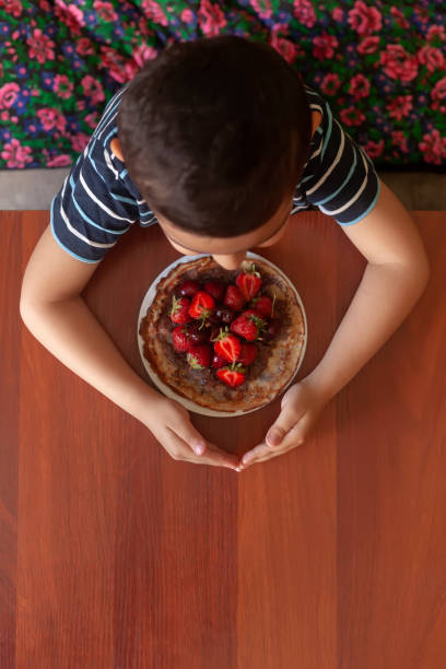 istock A greedy child with plate of thin pancakes 1151219623