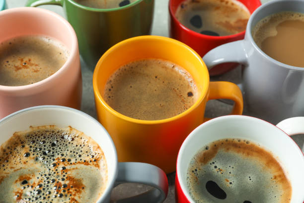 istock Multicolored cups of coffee on grey table as background, closeup 1151222243
