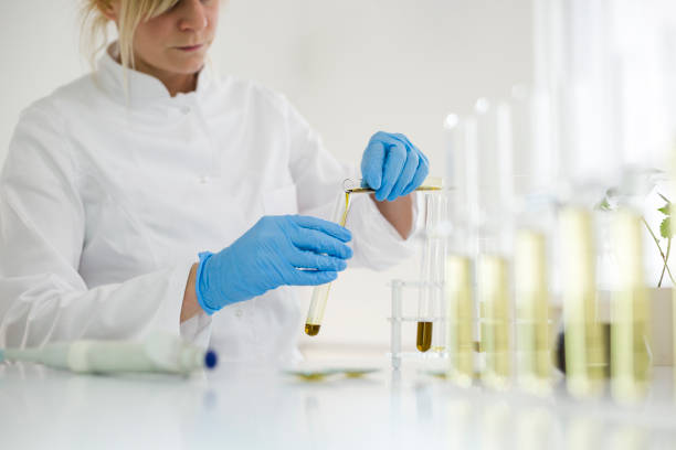 kvinnliga vetenskaps man i laboratoriet ester cbd olja utvinns ur en marijuana växt. hon använder ett flertal glasrör och skålar för experimentet. hälso-apotek från medicinsk cannabis. - carpel bildbanksfoton och bilder