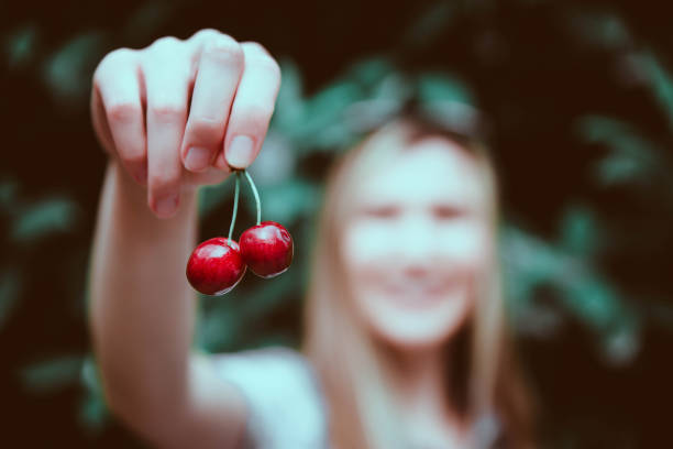 Young woman picking pomegranates from a tree in her backyard