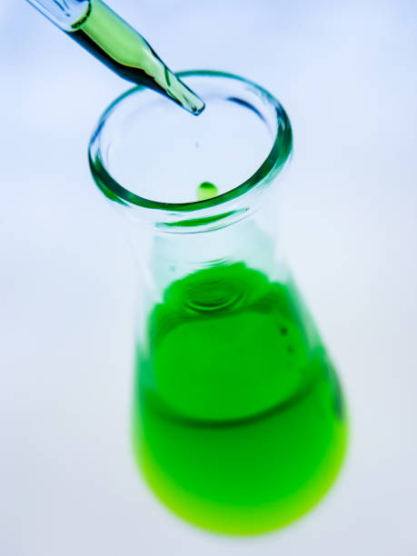 istock Sample dripping pipettes into Erlenmeyer bottles containing chemical green, background, close 1151223377