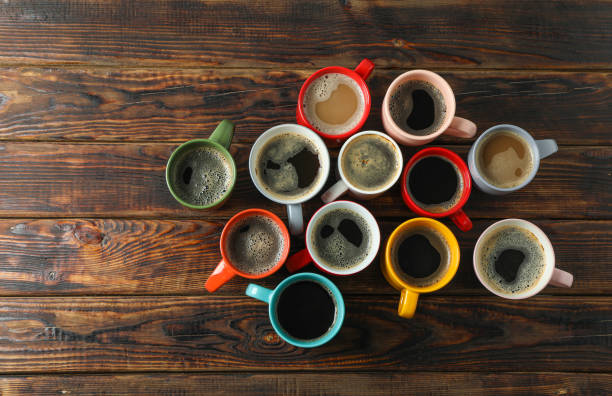 istock Multicolored cups of coffee on wooden background, top view and space for text 1151223697