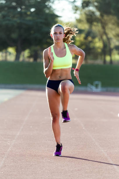 istock Fit young woman running on track field. 1151223939