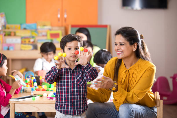 Teacher having fun with preschool boy