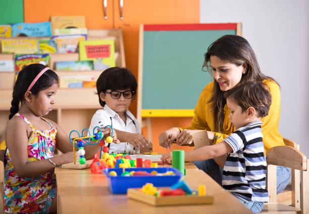 Teachers with children learning at preschool Teachers with children playing and learning at preschool school activity stock pictures, royalty-free photos & images