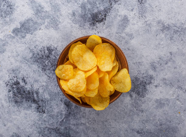 papas fritas crujientes en la vieja mesa de la cocina. vista desde arriba. - potatoe chips fotografías e imágenes de stock