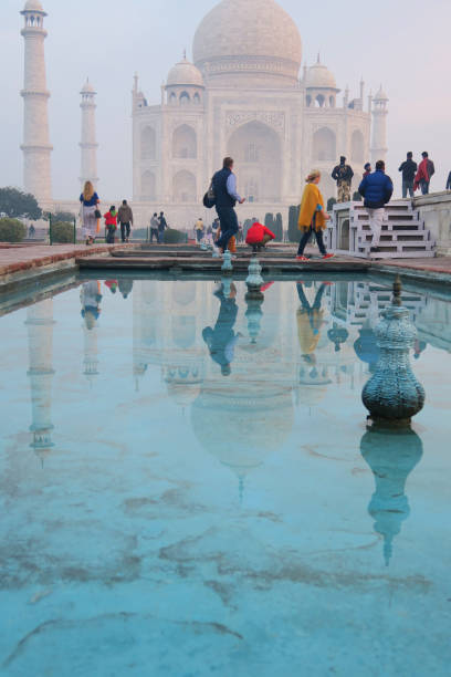 image des réflexions de piscine de lotus bleu à l’heure dorée de marbre blanc de l’architecture taj mahal, minarets et dômes d’oignon, les touristes tôt le matin du lever du soleil et les visiteurs en vacances dans la ville d’agra, uttar prade - agra architecture asia city of sunrise photos et images de collection