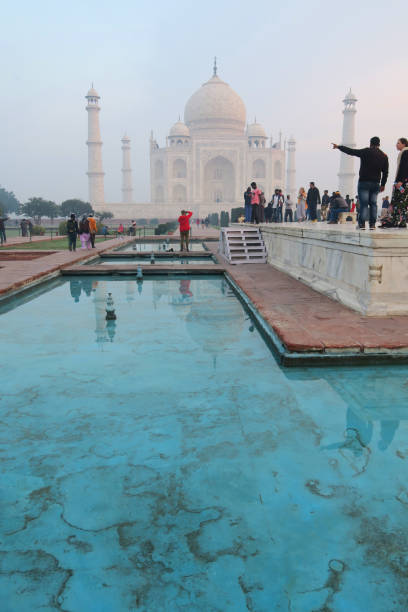 image des réflexions de piscine de lotus bleu à l’heure dorée de marbre blanc de l’architecture taj mahal, minarets et dômes d’oignon, les touristes tôt le matin du lever du soleil et les visiteurs en vacances dans la ville d’agra, uttar prade - agra architecture asia city of sunrise photos et images de collection