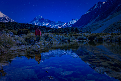 a Maori man take a relax in blue sky with star and soft Milky Way universe at the night in mt. cook