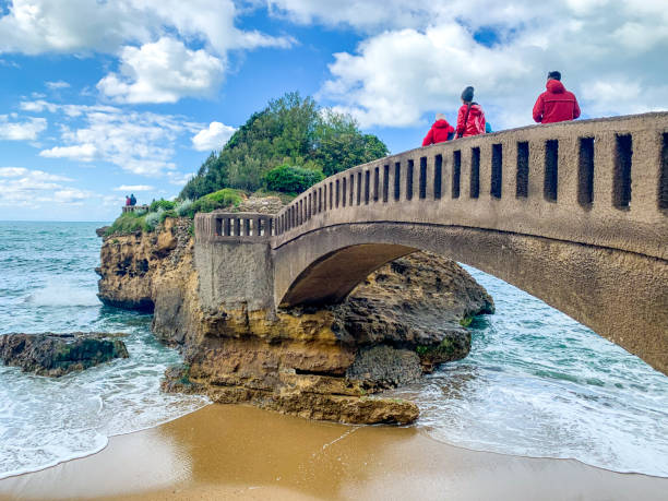 touristes marchant sur le pont à biarritz, france - rocher de la vierge photos et images de collection