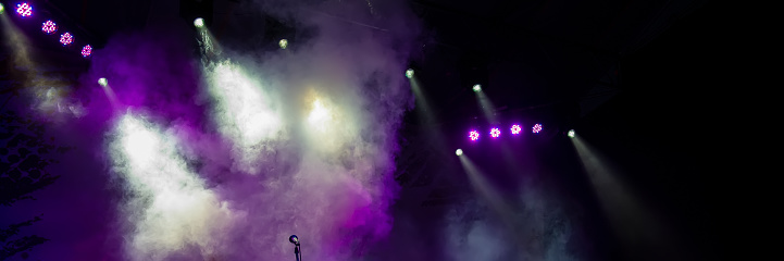 Concert stage lighting in the fog and microphone. Web banner.
