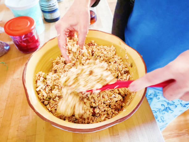 istock Close-up of hands mixing granola in ceramic bowl 1151237235
