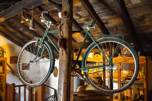 Old Vintage Bicycle hanging on a wooden column in the storage room