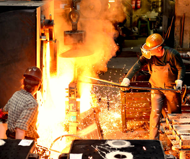 istock workers in a foundry casting a metal workpiece - safety at work and teamwork 1151244892