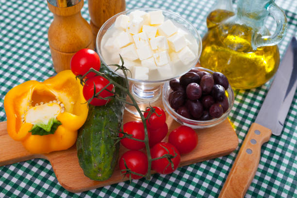istock Cooking Greek salad with mozzarella cheese. Ingredients on the table 1151244948