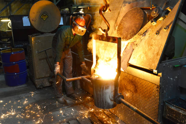 istock workers in a foundry casting a metal workpiece - safety at work and teamwork 1151245099
