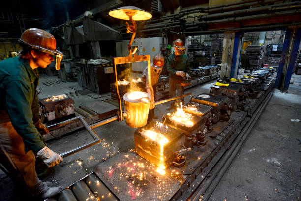 istock workers in a foundry casting a metal workpiece - safety at work and teamwork 1151245347