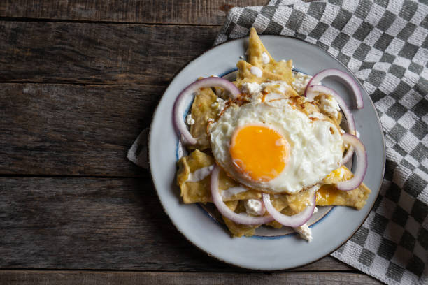 istock Mexican food: tasty green chilaquiles with fried egg, onion and fresh cheese 1151245376