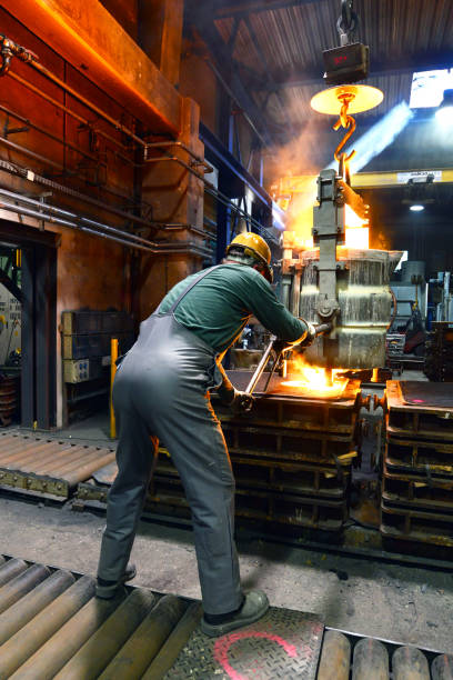 istock workers in a foundry casting a metal workpiece - safety at work and teamwork 1151247235