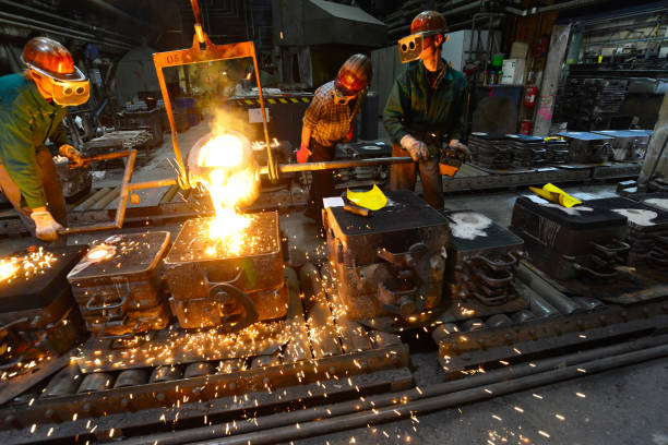 istock workers in a foundry casting a metal workpiece - safety at work and teamwork 1151247355