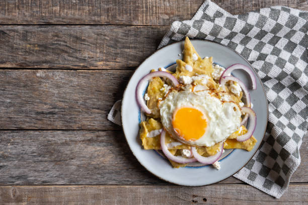 istock Mexican food: tasty green chilaquiles with fried egg, onion and fresh cheese 1151247592