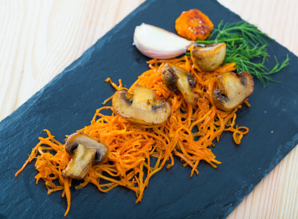 istock Slate of freshly fried mushrooms with carrot 1151248390