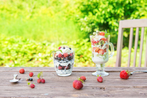 istock Layered dessert with raspberry, strawberry, black currant and kiwi, cream and biscuits in glasses 1151250006