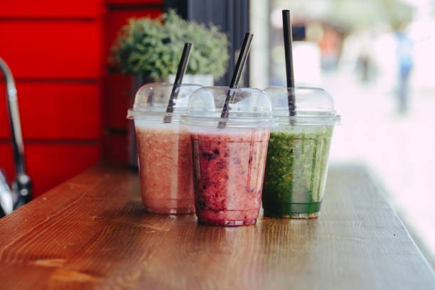 istock Sweet smoothie in plastic cups on wooden table 1151252857